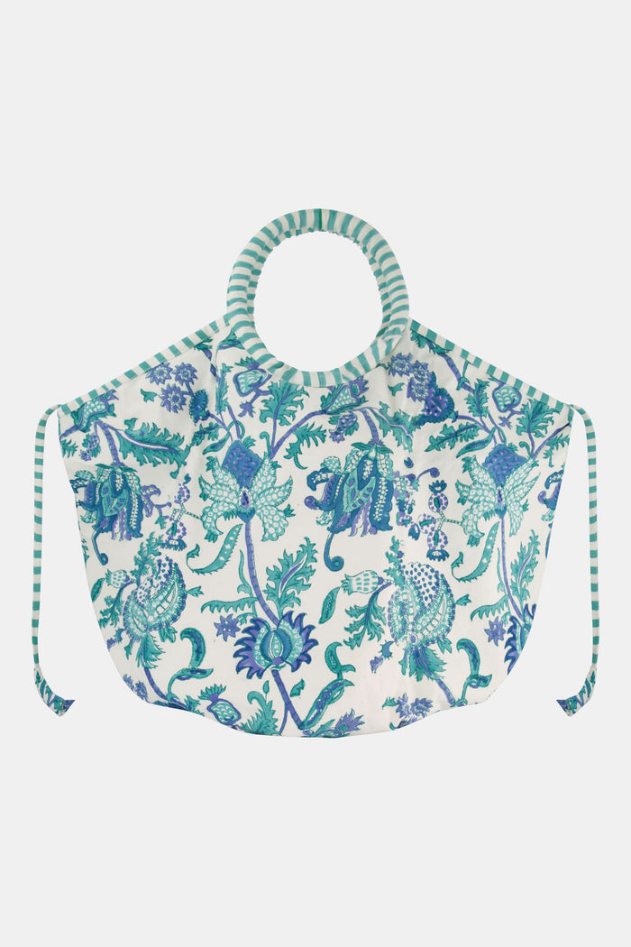 The Amanda Bondi Bag by Roller Rabbit is an oversized canvas bag with circular handles and side ties, showcasing a blue and green floral pattern on white plus blue-and-white striped accents—perfect for travel.