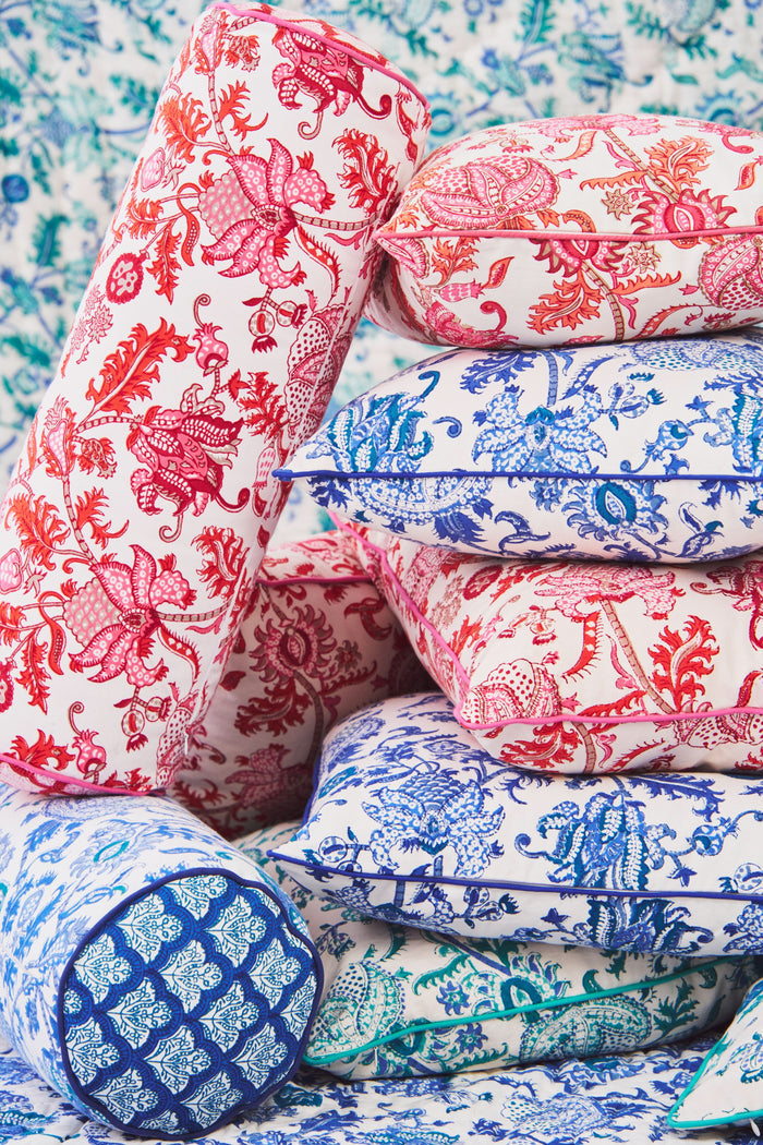 The Amanda Decorative Pillow by Roller Rabbit features a vibrant pink and red floral hand-blocked print on 100 cotton, white background, and is finished with pink piping along the edges.