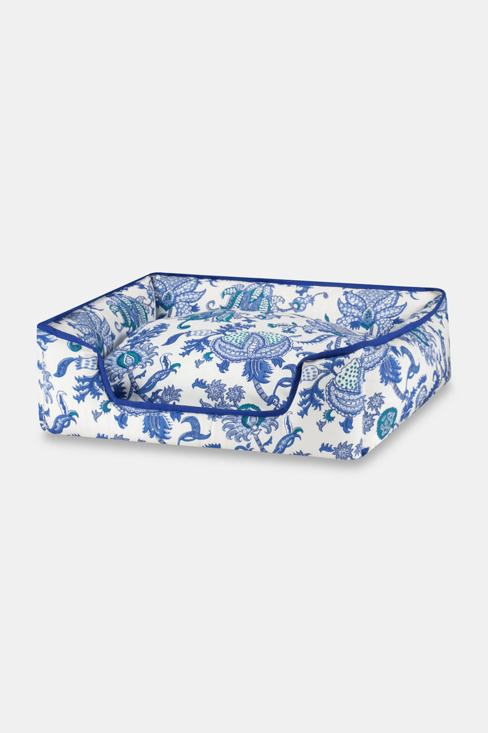 The Amanda Dog Bed by Roller Rabbit is a rectangular plush bed with raised sides, showcasing a blue floral and paisley pattern on a white background, photographed against a plain white backdrop.