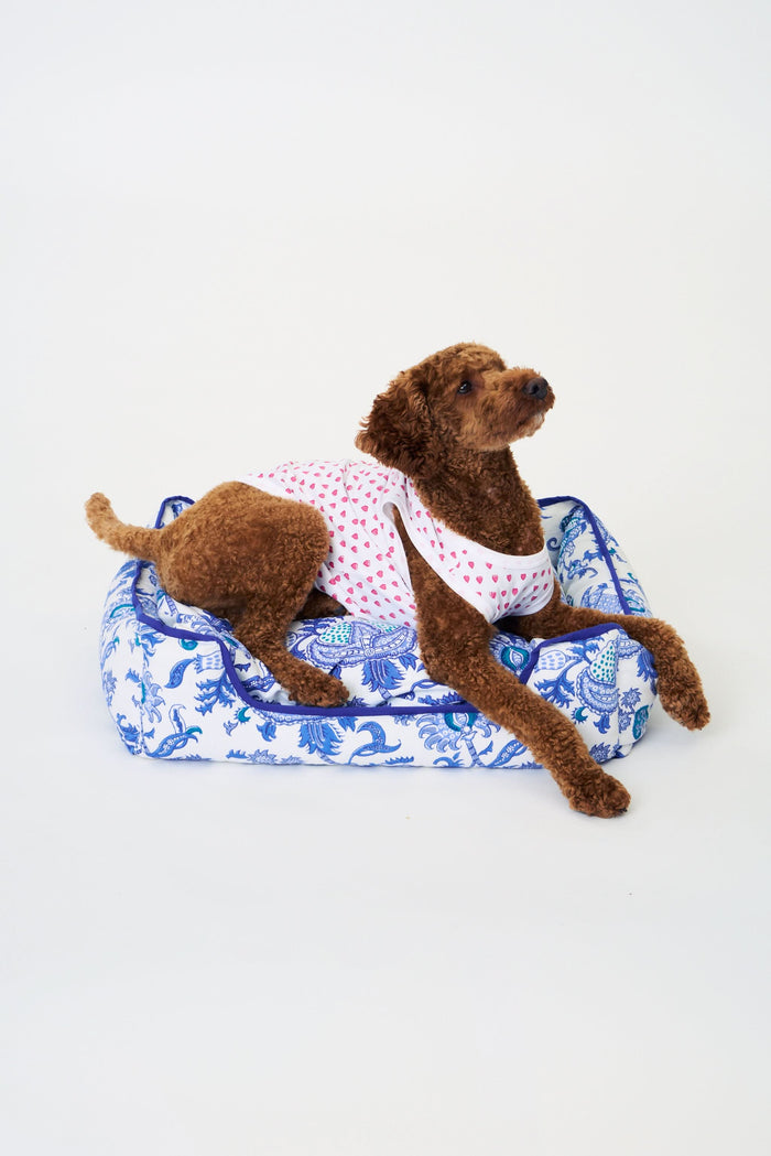 The Amanda Dog Bed by Roller Rabbit is a rectangular plush bed with raised sides, showcasing a blue floral and paisley pattern on a white background, photographed against a plain white backdrop.