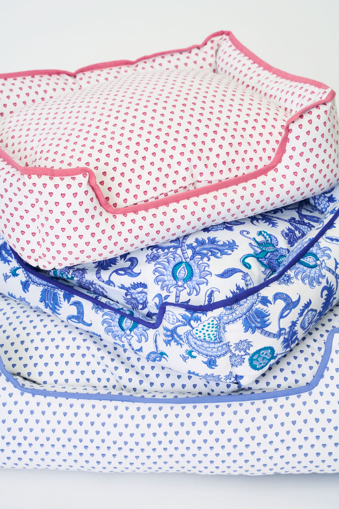 The Amanda Dog Bed by Roller Rabbit is a rectangular plush bed with raised sides, showcasing a blue floral and paisley pattern on a white background, photographed against a plain white backdrop.