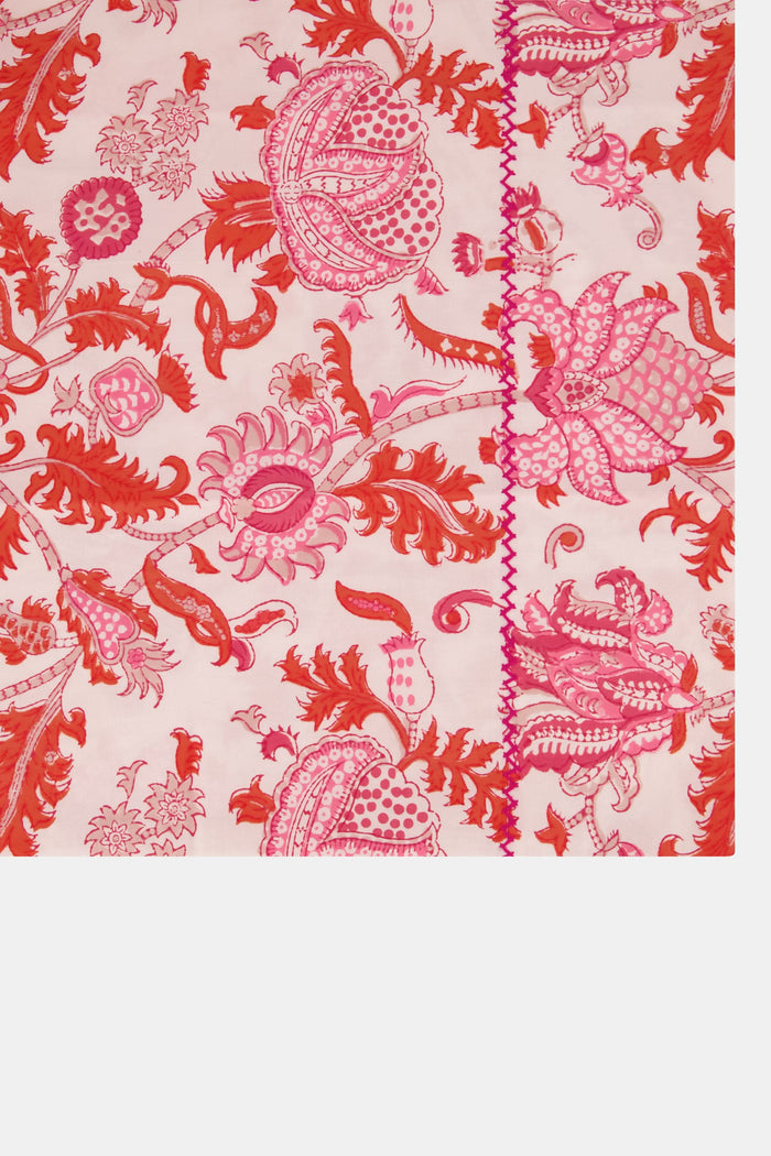 Two stacked pillows on a bed showcase the Roller Rabbit Amanda Pillowcase Set, featuring a vibrant red and pink floral and animal print on soft 300 thread count cotton, set against a white decorative headboard.