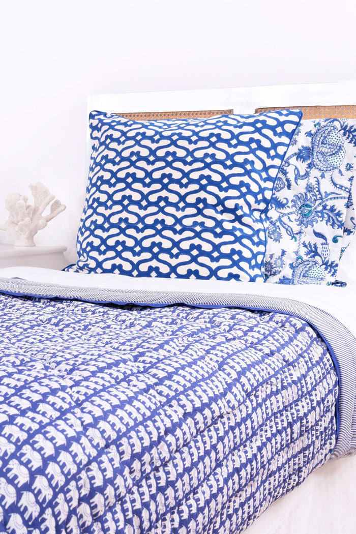 The Big Cata Decorative Pillow by Roller Rabbit features a bold geometric deep blue and white pattern with interlocking shapes, matching blue piped edge, 100 cotton cover, and a plain light-colored background.