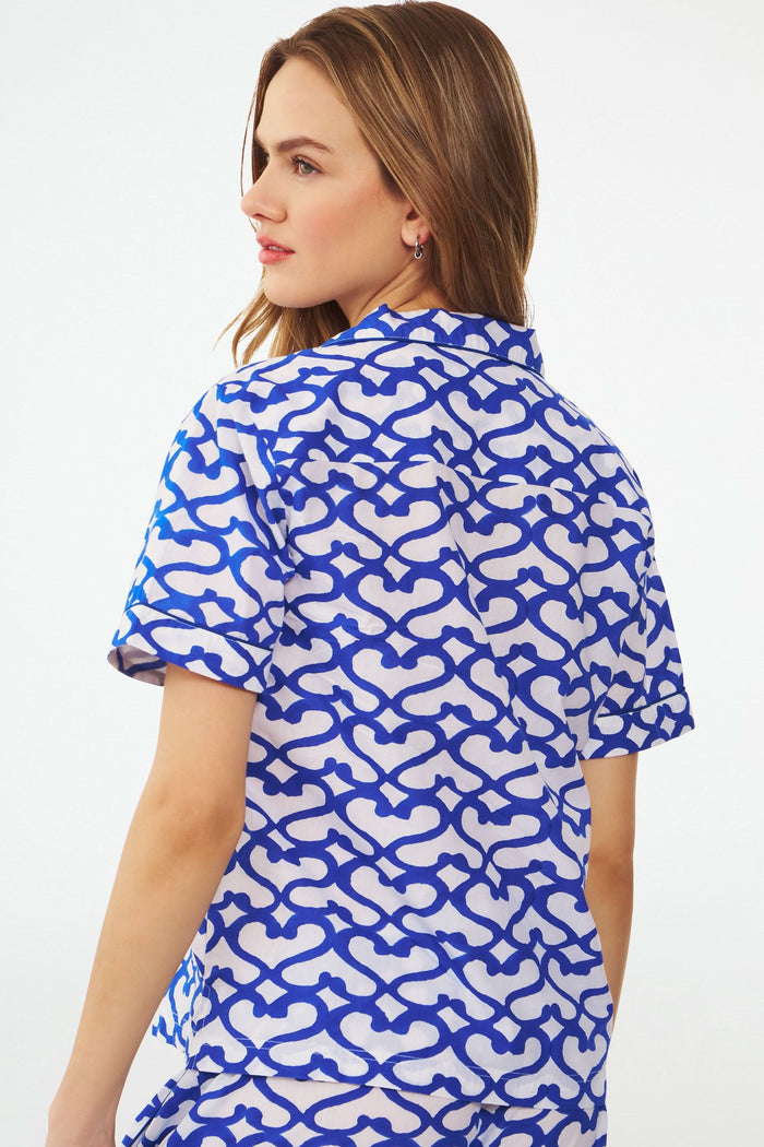 A woman stands barefoot in the Roller Rabbit Big Cata Liza Set, a matching short-sleeve pajama set made from cambric cotton with a blue and white Big Cata print, posing against a plain white background.