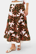 A person wears a white Roller Rabbit Blooming Daisies Carlisa Skirt with bold black and orange floral prints, paired with a white top and white sandals.