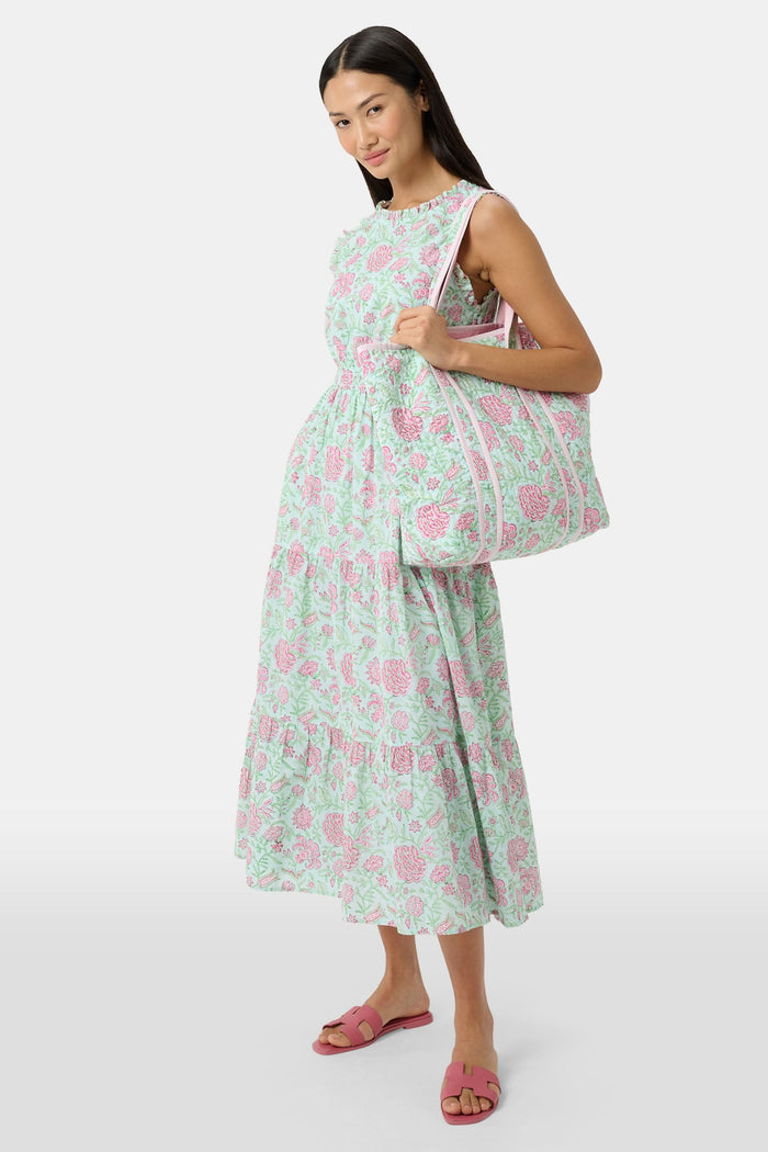 The Roller Rabbit Camellia Block Quilted Tote features pink and green floral patterns, a pale pink interior lining, and long white handles, shown on a plain white background.