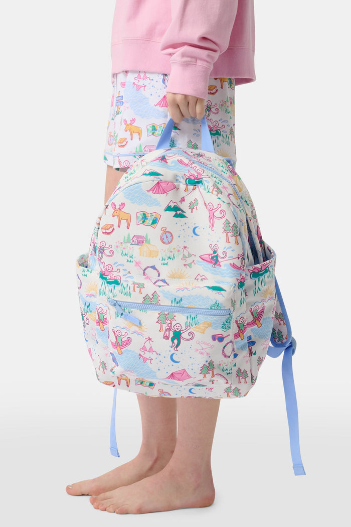 The Camp RR Backpack by Roller Rabbit features colorful cartoon camping scenes—mountains, animals, tents, trees, and rivers—plus playful characters in pink, blue, yellow, and green.