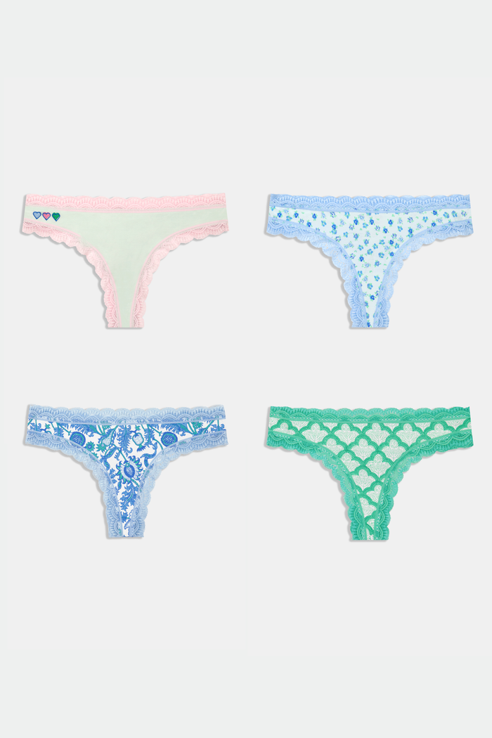 The Roller Rabbit Classic Core Thong 4 Pack features four pairs of lace-trim women’s underwear in pastel shades—pink with hearts, blue with flowers, printed blue, and green—offering soft cotton comfort and cute style.