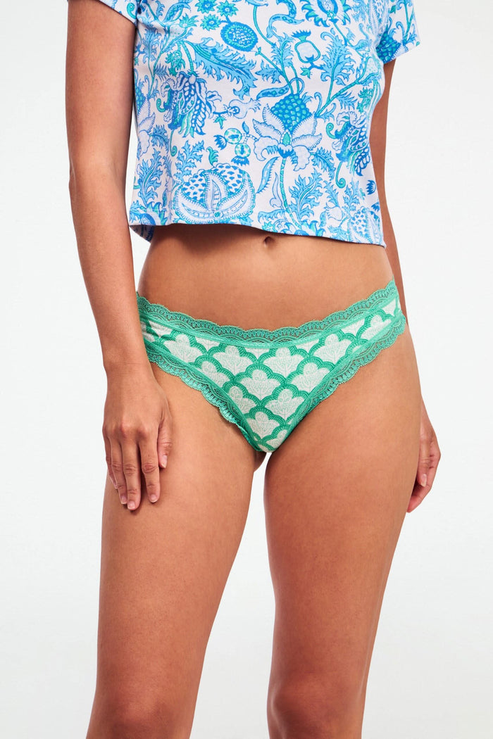 The Roller Rabbit Classic Core Thong 4 Pack features four pairs of lace-trim women’s underwear in pastel shades—pink with hearts, blue with flowers, printed blue, and green—offering soft cotton comfort and cute style.