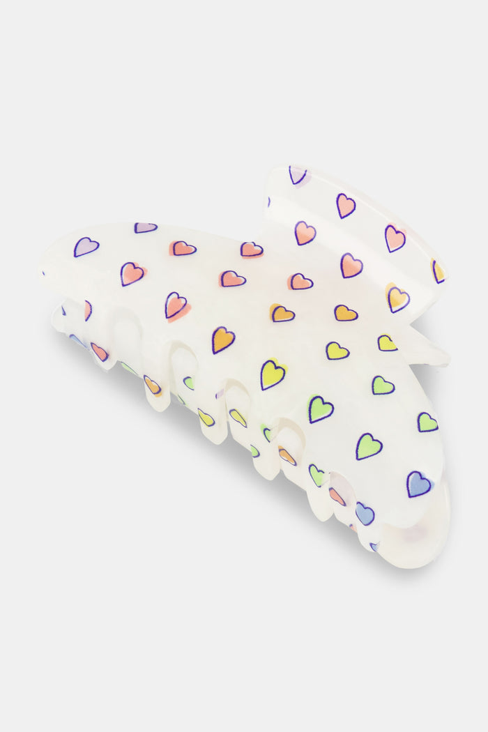 The Roller Rabbit Disco Hearts Claw Clip is a white hair accessory featuring a pattern of small multicolored hearts, displayed on a plain light background.