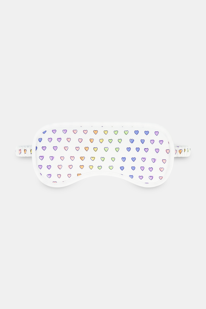 The Roller Rabbit Disco Hearts Eye Mask is a white Pima cotton mask with rows of small, colorful hearts and a matching strap—an ideal loungewear gift, shown against a plain white background.