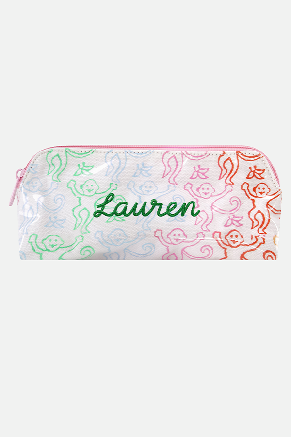The Disco Monkey Makeup Bag by Roller Rabbit is a white cotton canvas pouch with a water-resistant finish, featuring a playful pattern of green, blue, pink, and red smiling monkeys with curly tails.