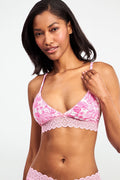 A woman with medium-length dark hair models the Ditsy Amanda Mercer Bralette by Roller Rabbit, featuring lace trim and a floral pattern, standing against a plain light background.
