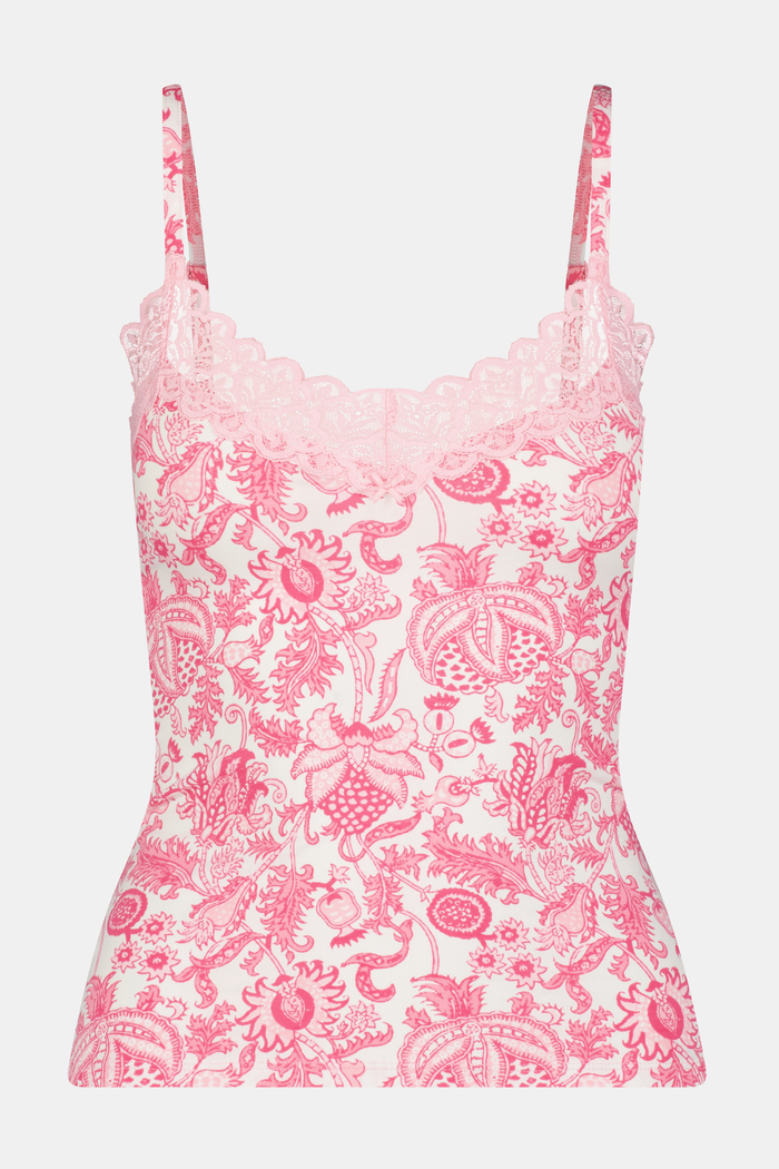 A woman with long brown hair poses confidently against a plain light background, wearing the Roller Rabbit Ditsy Amanda Perry Cami—a matching camisole and underwear set with pink and white floral lace and delicate scalloped trim.