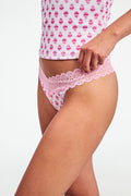 A person models the Roller Rabbit Ditsy Daisy Pointelle Jay Thong and a white tank top with pink cupcake patterns, standing against a plain white background. Only their torso and upper legs are visible.