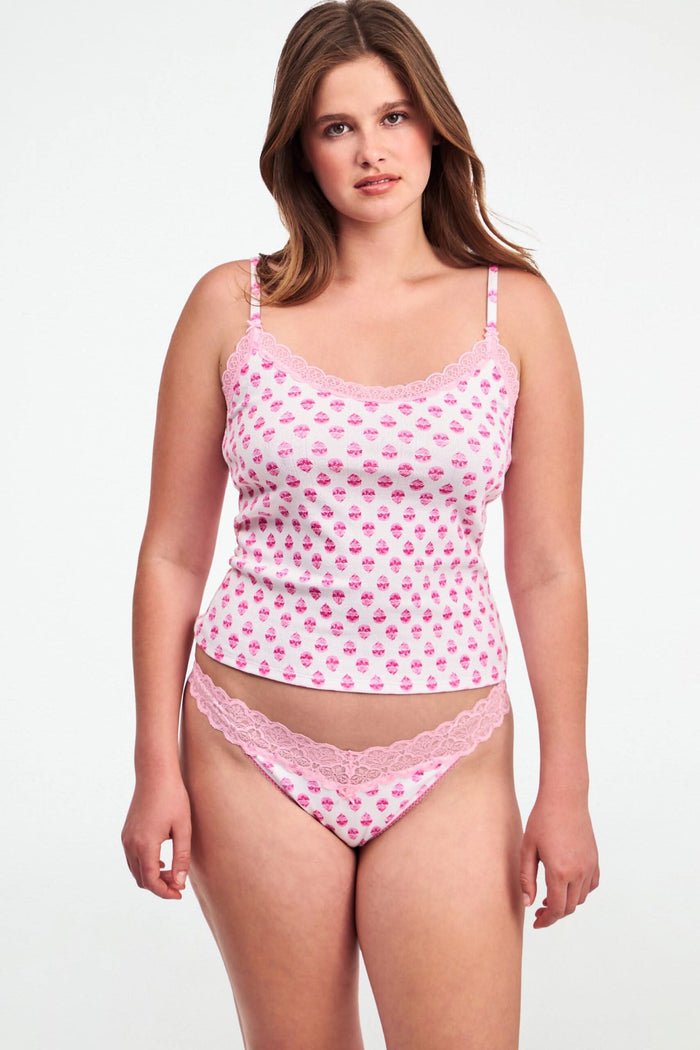 A person models the Roller Rabbit Ditsy Daisy Pointelle Jay Thong and a white tank top with pink cupcake patterns, standing against a plain white background. Only their torso and upper legs are visible.