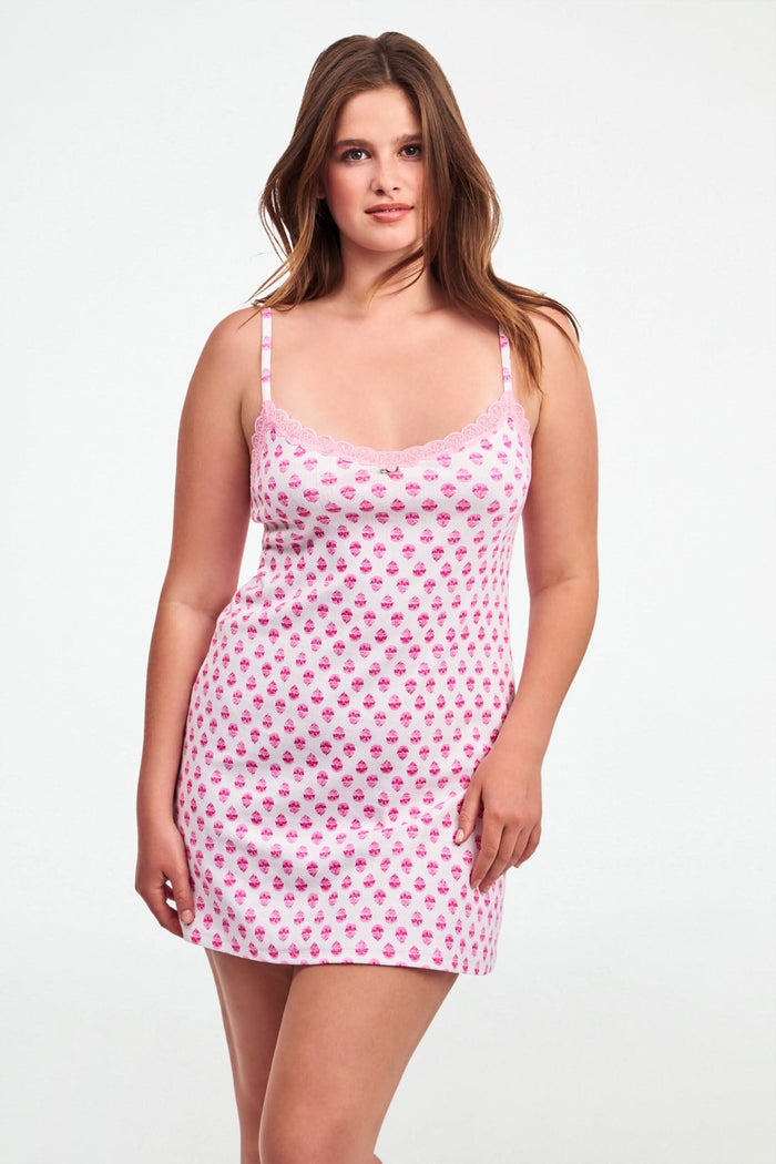 A woman wearing the Roller Rabbit Ditsy Daisy Pointelle Pearl Slip Dress with thin straps and a daisy pattern poses against a plain light background.