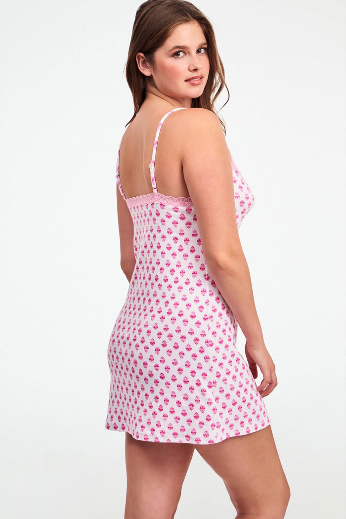 A woman wearing the Roller Rabbit Ditsy Daisy Pointelle Pearl Slip Dress with thin straps and a daisy pattern poses against a plain light background.
