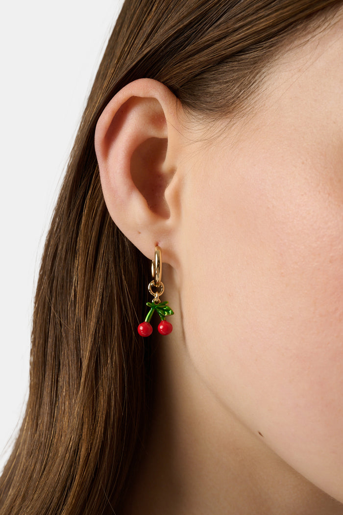 The Roller Rabbit Fruits D'Eete Hoop Earring Pack features two gold huggie pairs: one with cherry charms, the other with strawberry charms. Mix and match for a playful summer accessory combo.