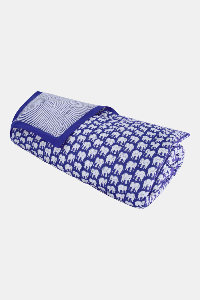 The Roller Rabbit Hathi Baby Quilt features a blue background with a white elephant print, blue and white striped lining, and a solid blue border, all crafted from soft cotton for comfort.