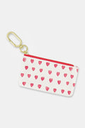 The Roller Rabbit Hearts Coin Pouch is a small white cotton canvas pouch with pink watercolor hearts, a red zipper, and a gold keyring and clasp, shown against a plain white background.