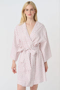 A woman stands barefoot, smiling in a Roller Rabbit Hearts Kimono with a matching belt, set against a plain white background.
