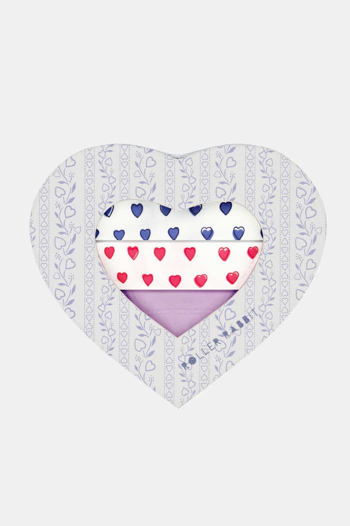 The Roller Rabbit Hearts Lace Thong 3 Pack features three thongs displayed vertically: blue hearts on top, solid lavender in the middle, and red hearts on the bottom, each with a center bow for a comfy and cute look.