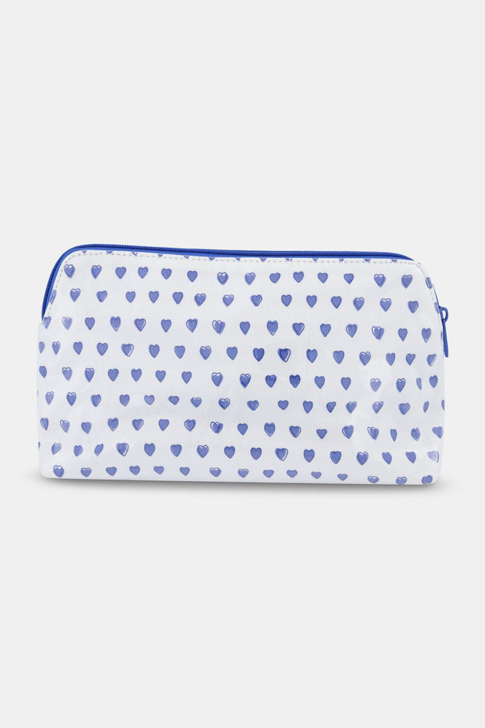 The Roller Rabbit Hearts Makeup Bag is a white water-resistant canvas pouch with a blue zipper and an all-over blue heart print.