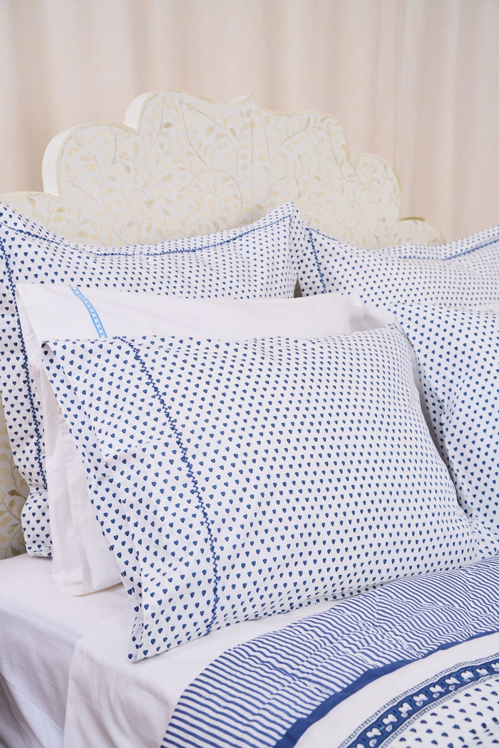 The Roller Rabbit Hearts Pillowcase Set features two white 100 cotton pillowcases with small blue leaf patterns, offering breathable comfort and style to your space. Shown stacked on a white surface against a cream-colored background.