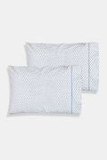 The Roller Rabbit Hearts Pillowcase Set features two white 100 cotton pillowcases with small blue leaf patterns, offering breathable comfort and style to your space. Shown stacked on a white surface against a cream-colored background.