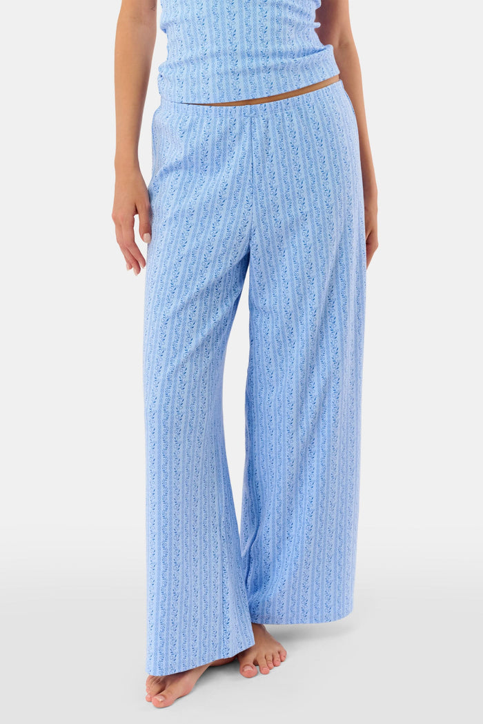 A person models the Roller Rabbit Hearts Vine Monroe Pant—loose-fitting, light blue pajama bottoms with a subtle vertical pattern. The image highlights only the lower body and the comfort of the cotton pointelle fabric.