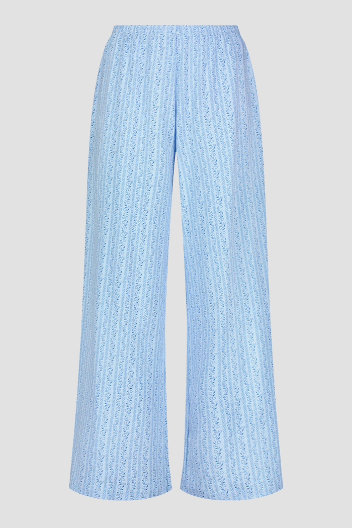 A person models the Roller Rabbit Hearts Vine Monroe Pant—loose-fitting, light blue pajama bottoms with a subtle vertical pattern. The image highlights only the lower body and the comfort of the cotton pointelle fabric.