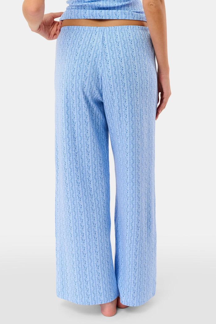 A person models the Roller Rabbit Hearts Vine Monroe Pant—loose-fitting, light blue pajama bottoms with a subtle vertical pattern. The image highlights only the lower body and the comfort of the cotton pointelle fabric.