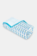 The Roller Rabbit Hoppy Baby Quilt features a playful blue and yellow Hoppy the Bunny pattern on white cotton, accented with a blue border and shown rolled up on a light surface.
