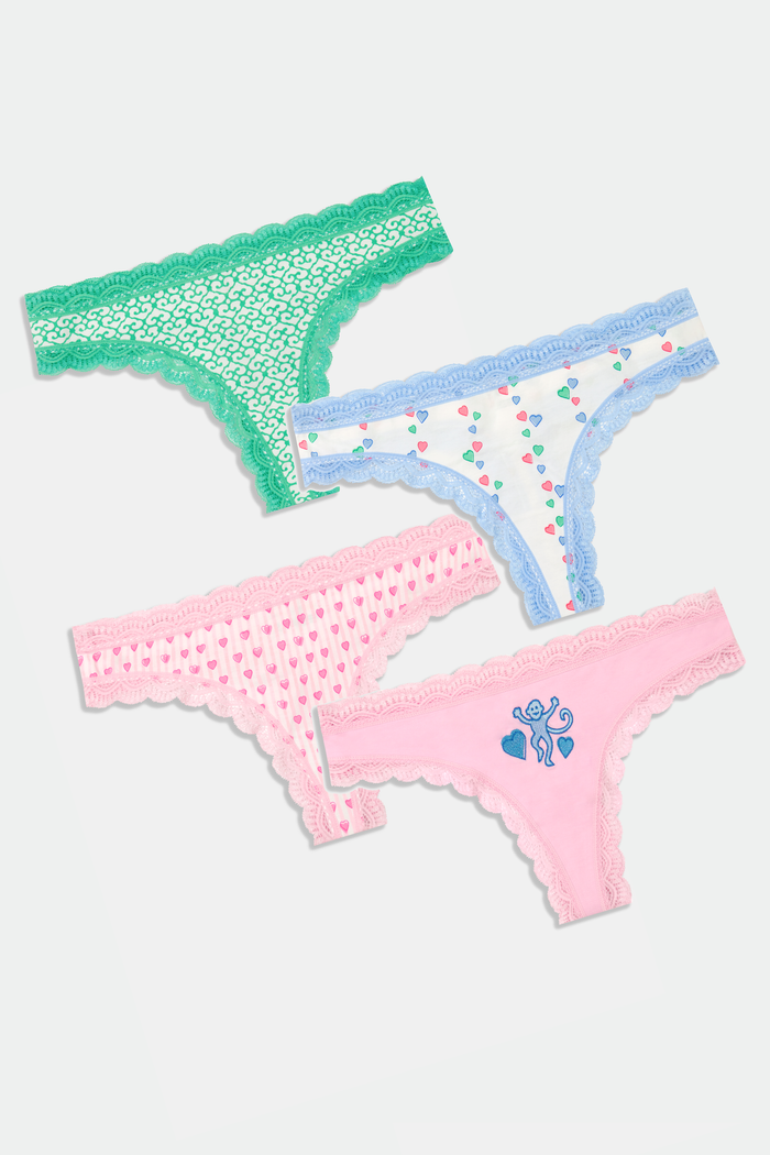 The Roller Rabbit Icons Thong 4 Pack includes lace-trimmed women’s cotton thongs in green, light blue with hearts, pale pink with hearts, and pale pink with a blue butterfly design.