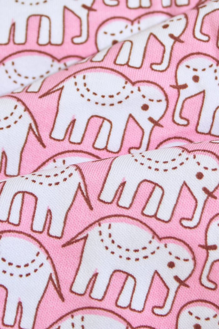 The Roller Rabbit Infant Hathi Receiving Blanket features a pink and white elephant pattern, white trim, and is crafted from premium cotton. Neatly folded to display both sides.
