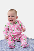 A smiling baby with light skin and short hair sits on a blue and white striped blanket wearing the Roller Rabbit Infant Leo The Lion Zipper Footie, made from soft Pima cotton with a convenient two-way zipper for easy dressing.