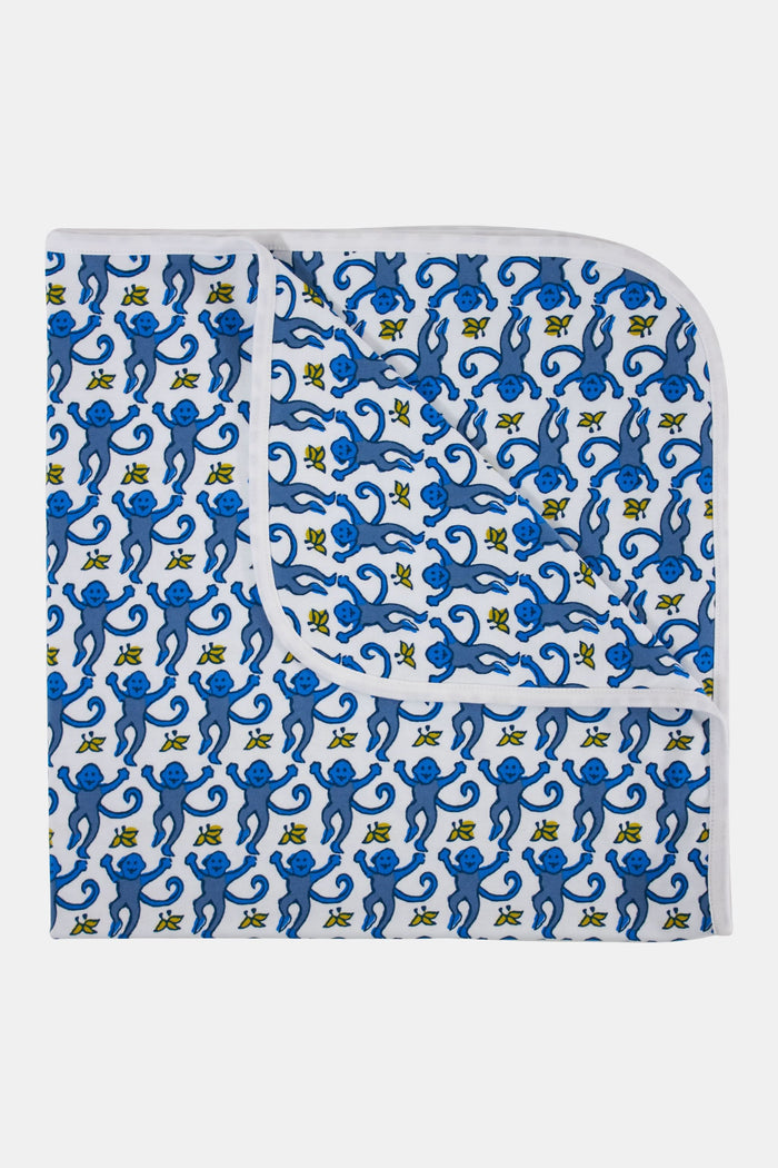 The Roller Rabbit Infant Monkey Receiving Blanket is a white Pima cotton baby blanket with a blue monkey and yellow banana pattern, rounded corners, and a folded edge.