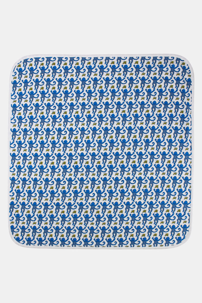 The Roller Rabbit Infant Monkey Receiving Blanket is a white Pima cotton baby blanket with a blue monkey and yellow banana pattern, rounded corners, and a folded edge.