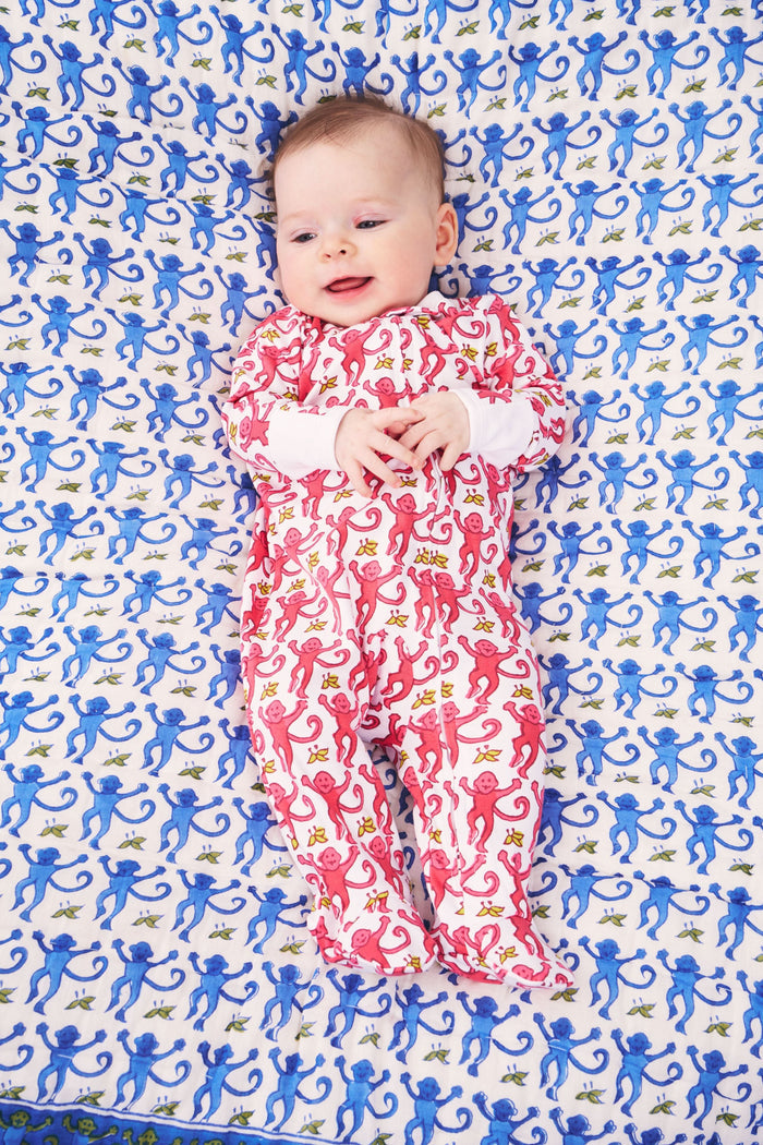 The Roller Rabbit Infant Monkey Zipper Footie features a playful pink monkey pattern with yellow accents, long sleeves and legs, and is crafted from premium cotton. It’s shown laid flat on a plain background.