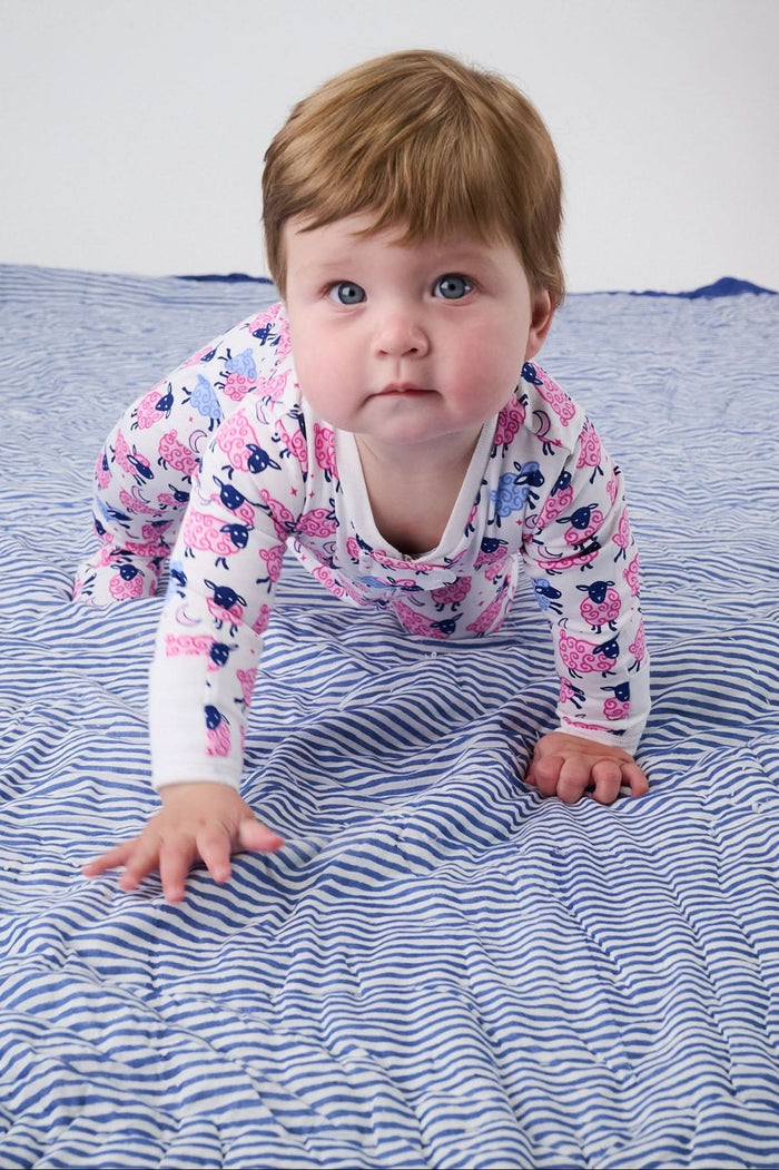 The Roller Rabbit Infant Sammy The Sheep Zipper Footie is a long-sleeve, full-leg sleeper with a two-way zipper and features a white background with pink and blue cats, paisley designs, and made from soft Pima cotton.