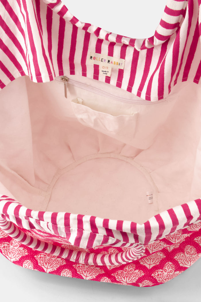 The Jemina Bondi Bag by Roller Rabbit is a large pink and white cotton canvas tote featuring a scalloped pattern, striped handles, and side drawstrings, shown against a plain white background.