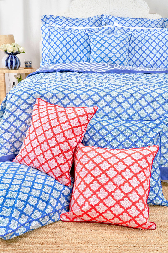 The Jemina Decorative Pillow by Roller Rabbit features a red and white scallop pattern with floral accents, red piping, and is crafted from 100 cotton on a plain white background.