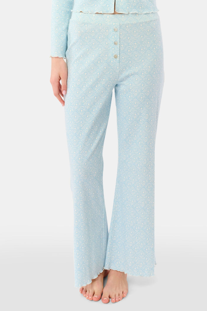 A person stands barefoot, showing only their lower torso and legs while wearing Roller Rabbit's Jemina Hearts Pointelle Michelle Pant in pale blue.