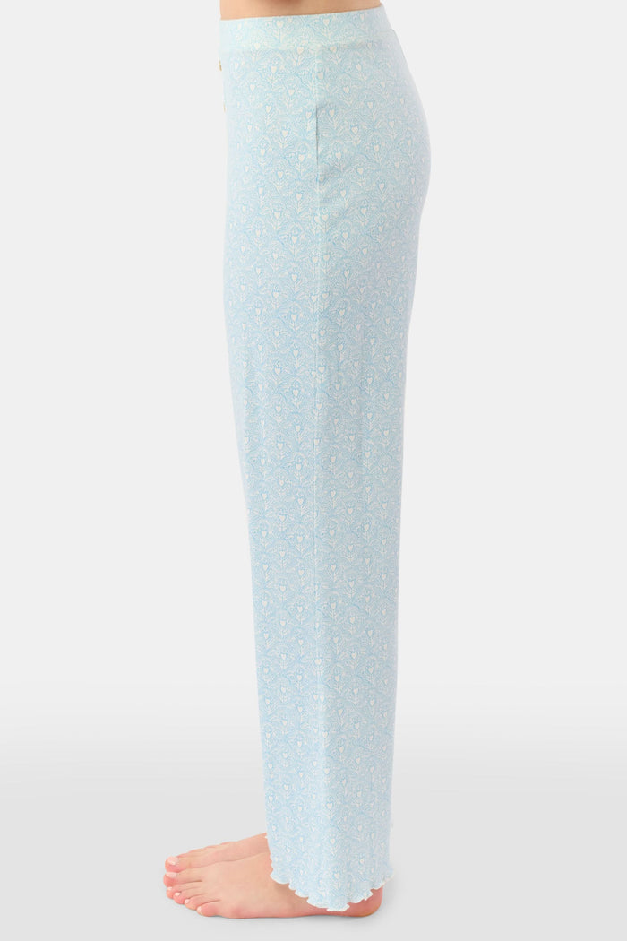 A person stands barefoot, showing only their lower torso and legs while wearing Roller Rabbit's Jemina Hearts Pointelle Michelle Pant in pale blue.