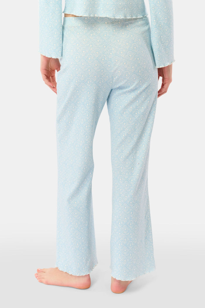 A person stands barefoot, showing only their lower torso and legs while wearing Roller Rabbit's Jemina Hearts Pointelle Michelle Pant in pale blue.