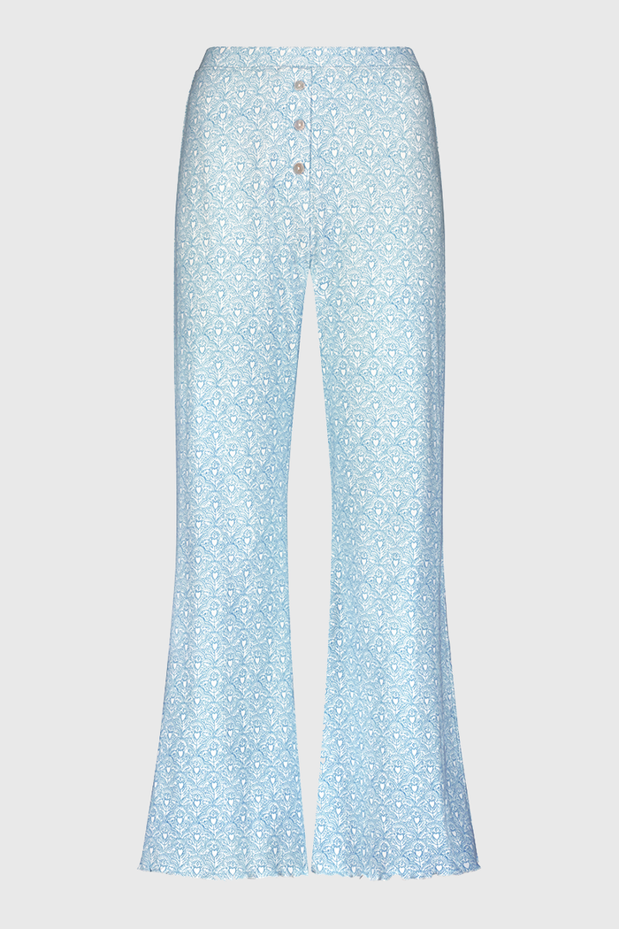 A person stands barefoot, showing only their lower torso and legs while wearing Roller Rabbit's Jemina Hearts Pointelle Michelle Pant in pale blue.