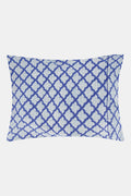 The Roller Rabbit Jemina Pillowcase Set features a blue and white geometric print, stacked on a matching bedspread with a white headboard and curtain. Made from 100 cotton, it brings style to any bedroom.