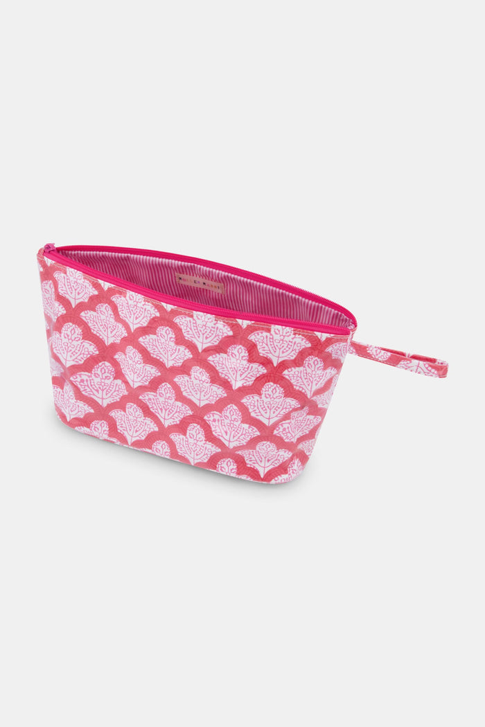 The Jemina Toiletry Case by Roller Rabbit features a pink zippered design with a white floral pattern and matching pink strap, shown against a plain white background. Perfect for organizing your travel essentials.