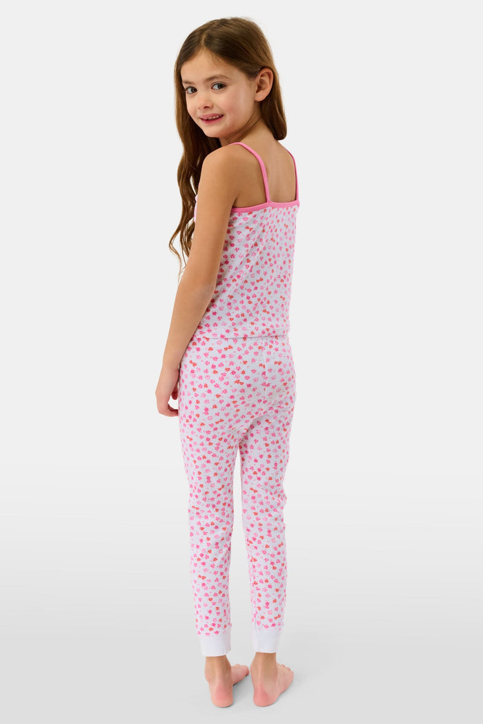 A young girl with long brown hair wears the Roller Rabbit Kids Bouquet Campbell Set, a pink and white pajama set with a floral print. She stands barefoot, smiling, against a plain light background with one foot slightly raised.